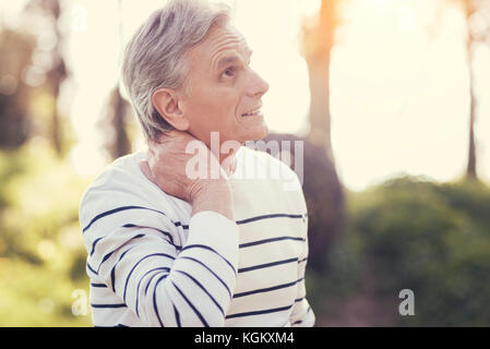 Schön angenehm Mann seinen Hals Holding Stockfoto