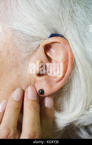 Zugeschnittenes Bild der älteren Frau das Tragen von Hörgeräten Stockfoto