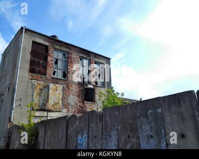 Verlassene Fabrikgebäude in Polen mit blauem Himmel und weißen Wolken. Stockfoto