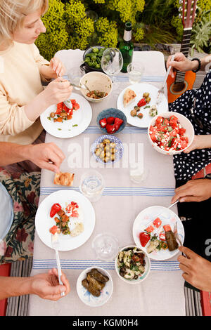 Direkt über dem Schoß der männlichen und weiblichen Freunde Mittagessen im Tisch Stockfoto