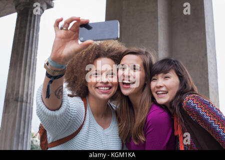 Low Angle View von lächelnden jungen weiblichen Freunde unter selfie Stockfoto
