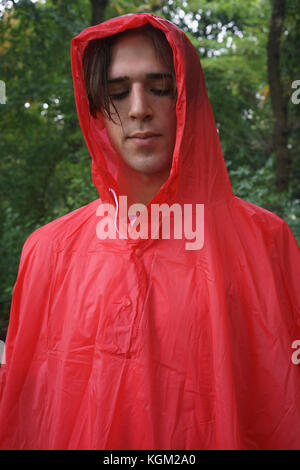 Nahaufnahme der junge Mann das Tragen der roten Regenjacke im Park Stockfoto