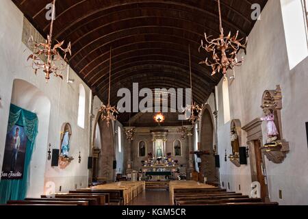 Innenraum der Kirche Templo de Nuestra Señora del Sagrario mit einer Holzfassdecke und kupferfarbenen Kronleuchtern in Santa Clara del Cobre, Michoacan, Mexiko. Stockfoto