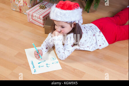 Kleine Mädchen die Vorbereitung der Santa schreiben. Sie malen ein Blatt mit Kopfzeile in Englisch Stockfoto