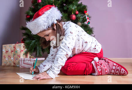 Kleine Mädchen die Vorbereitung der Santa schreiben. Sie malen die Geschenke, die Sie möchten. Pre-reader Konzept Stockfoto