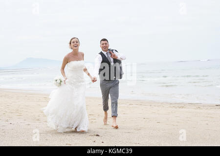 Fröhlich frisch verheiratete Ehepaar auf einem Sandstrand Stockfoto