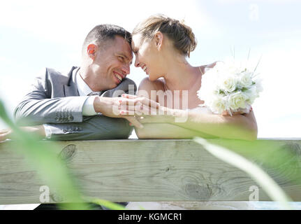 Portrait von Braut und Bräutigam schiefen auf Zaun Stockfoto