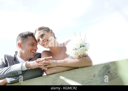 Portrait von Braut und Bräutigam schiefen auf Zaun Stockfoto