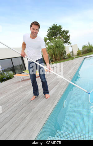 Mann Reinigung Schwimmbad in privater Villa Stockfoto