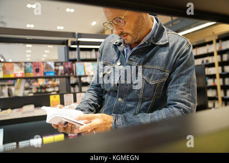 Mann in der Buchhandlung an neue Bücher suchen Stockfoto