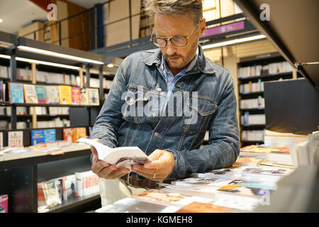 Mann in der Buchhandlung an neue Bücher suchen Stockfoto