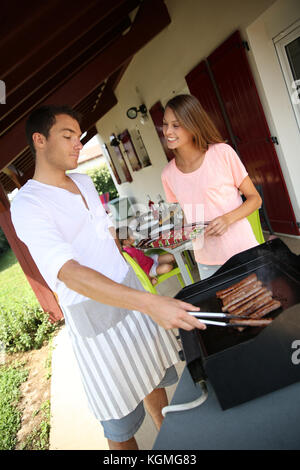 Paar kochen Fleisch vom Grill zu Hause Stockfoto
