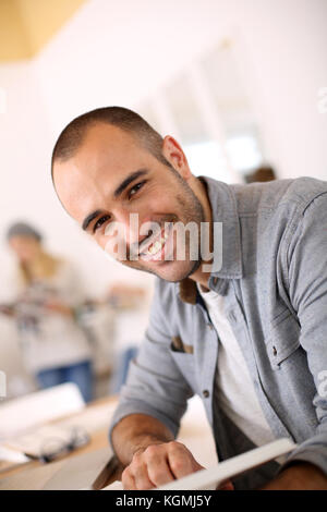 Lächelnden jungen Mann lesen Buch Stockfoto