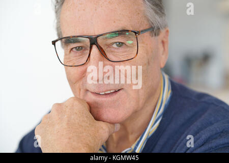 Älterer Mann mit Brille lesen Zeitung Stockfoto