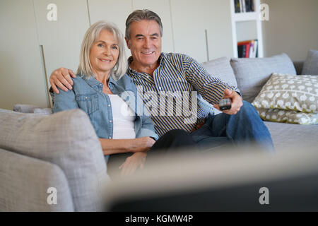 Senior Paar auf der Couch vor dem Fernseher sitzen Stockfoto