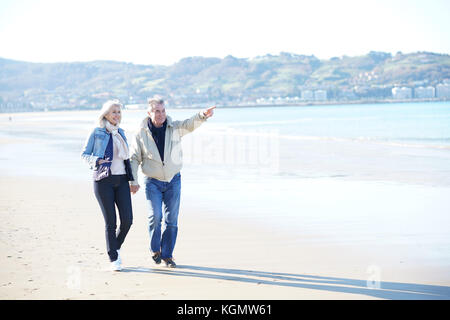 Senior Paar an einem Sandstrand im Winter Stockfoto