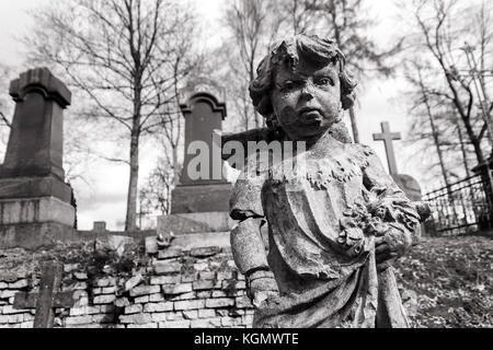 Statue des kleinen Jungen Engel an rasu Friedhof in Vilnius, Litauen. schwarz-weiß-Bild Stockfoto