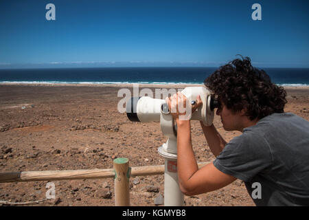 Junge mit einem touristische Teleskop oder Turm Viewer bei Cofete Beach, Fuerteventura. Hintergrundbild mit kopieren. Stockfoto