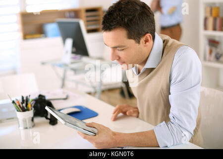 Hübscher Kerl arbeiten mit Tablet-PC im Büro Stockfoto