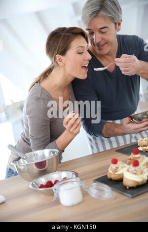 Mann seine Frau Verkostung Kuchen in Vorbereitung Stockfoto