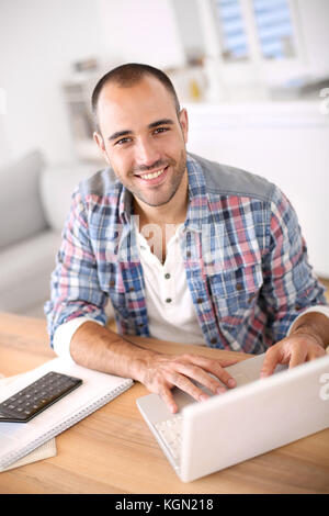 Mann auf Laptop von zu Hause aus arbeiten Stockfoto