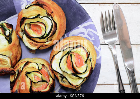 Typisch spanischen Essen mit etwas Gemüse und geräuchertem Lachs gerollt Blumen bilden. Weiße Holztisch von oben. Stockfoto