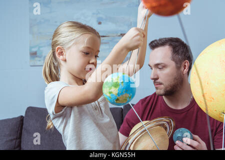 Vater und Tochter spielen mit Planeten Stockfoto