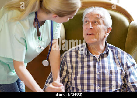 Portrait von gerne ältere Mann an Krankenschwester kümmert sich um Ihn suchen Stockfoto