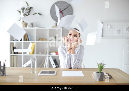 Fröhliche geschäftsfrau am Schreibtisch im Büro Stockfoto