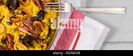 Meeresfrüchte Paella in traditionellen Pan auf rustikalen Holztisch Stockfoto