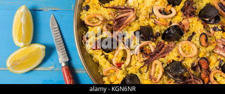 Spanische Paella in traditionellen Pan auf rustikalen Holztisch Stockfoto