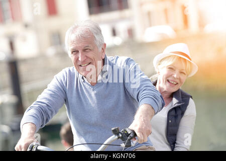 Seniorenpaar, das Spaß beim Fahrradfahren in der Touristengegend hat Stockfoto