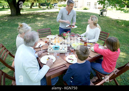Familie in Sommer Mittagessen im Garten Stockfoto