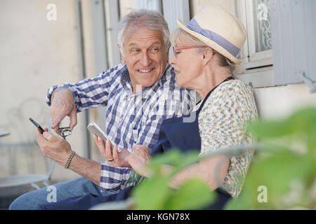 Senior Paar von Haus am Smartphone suchen Stockfoto
