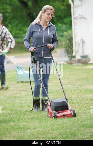 Frau im Garten Rasen mähen Stockfoto