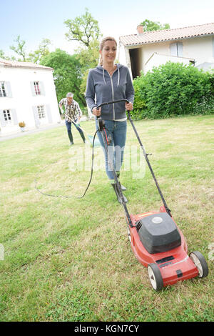 Frau im Garten Rasen mähen Stockfoto