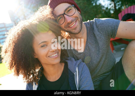 Fröhliche trendige Paar im Park am Morgen sitzen Stockfoto