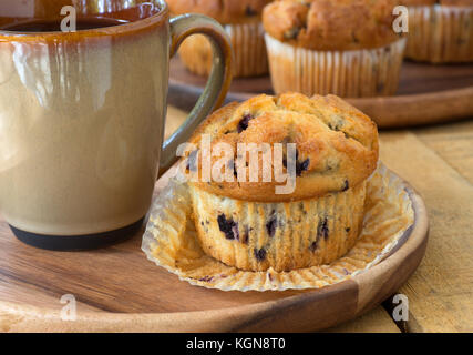 Blueberry Muffin und Tasse Kaffee auf einer Holzplatte Stockfoto