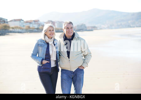 Senior Paar an einem Sandstrand im Winter Stockfoto