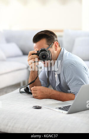 Mann an mit Digitalkamera und Laptop Stockfoto