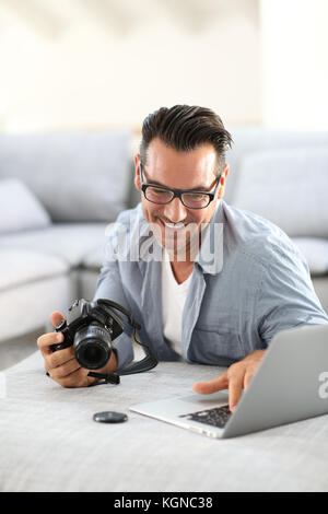 Mann an mit Digitalkamera und Laptop Stockfoto