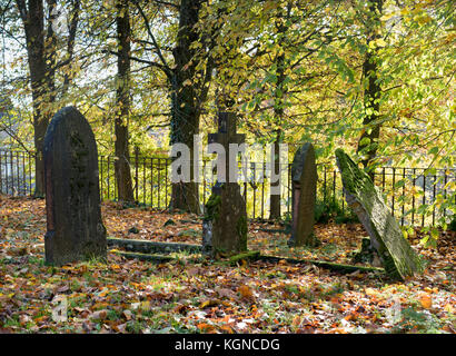 Grabsteine auf dem Friedhof der All Saints Church im Herbst. Bisley, Cotswolds, Gloucestershire, England Stockfoto