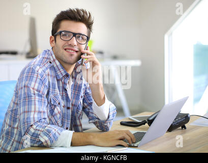 Trainee im Büro, am Telefon zu sprechen Stockfoto