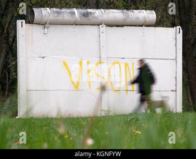 Groß Glienicke, Deutschland. November 2017. Ein Fußgänger passiert ein ursprüngliches Stück der Berliner Mauer in einer ehemaligen Boder-Zone. Am Abend des 9. November 1989 kündigte der ehemalige SED-Politbüro Günter Schabowski fast nebenbei an, dass eine Reise in den Westen ab diesem Zeitpunkt möglich sei. Später in der Nacht fiel die Mauer. Neueste wissenschaftliche Erkenntnisse zeigen, dass allein in Berlin mehr als 140 Bürger in Händen der DDR-Grenzkontrolle getötet wurden. Quelle: dpa Picture Alliance/Alamy Live News Stockfoto