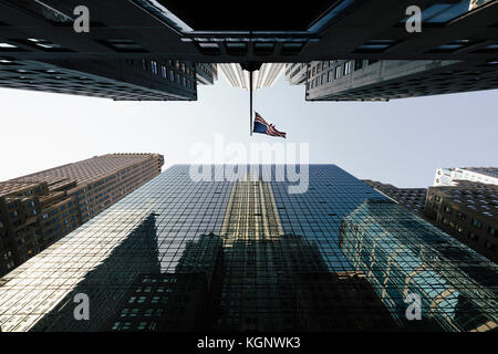 Direkt unter Ansicht der amerikanischen Flagge inmitten modernen Büro Wolkenkratzer gegen den Himmel, New York, USA Stockfoto