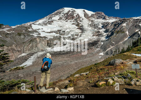 Mount Rainier über Nisqually Gletscher, mit Steinen bedeckt, Wanderer im Glacier Vista, Skyline Trail, Ende September, Mount Rainier National Park, Washingt Stockfoto