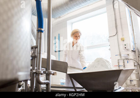 Frau an Ice Cream Factory Förderband arbeiten Stockfoto