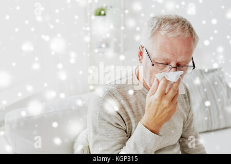 kranker senior Mann mit Papier abwischen seine Nase weht Stockfoto
