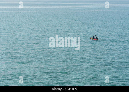 Twin seat Sea Kayak, Paddelten zum Meer durch zwei Kanuten. Sie sind Position heraus zu Line-Fisch für Makrele in flachen Gewässern. Isolierte Konzept. Stockfoto