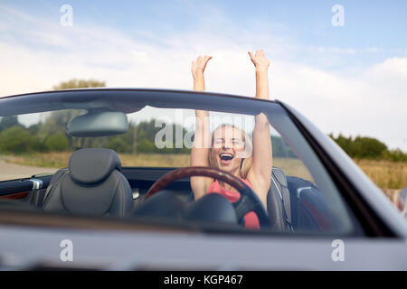 Glückliche junge Frau in Cabrio Stockfoto